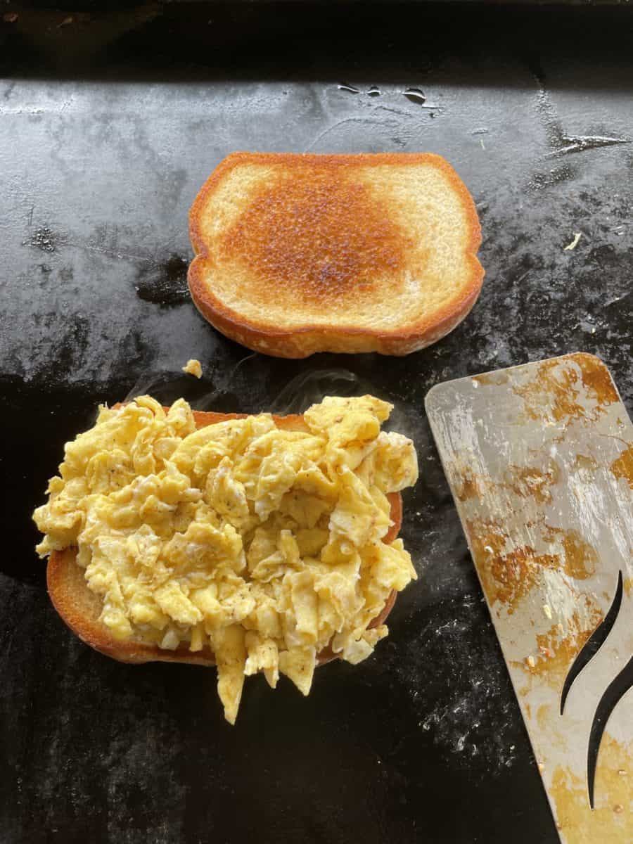 Place Scrambled Eggs on Toasted Bread.