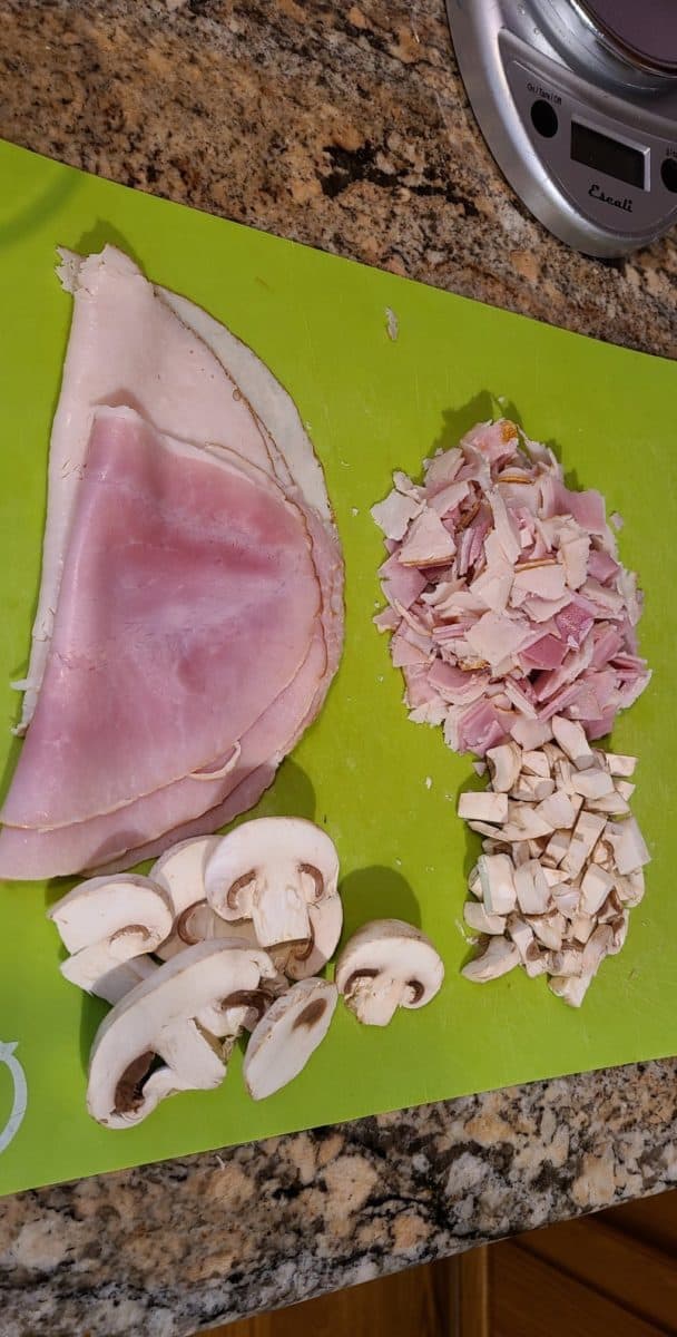Sliced Turkey, Ham, and Mushrooms. Then all is diced into small pieces on a cutting mat.