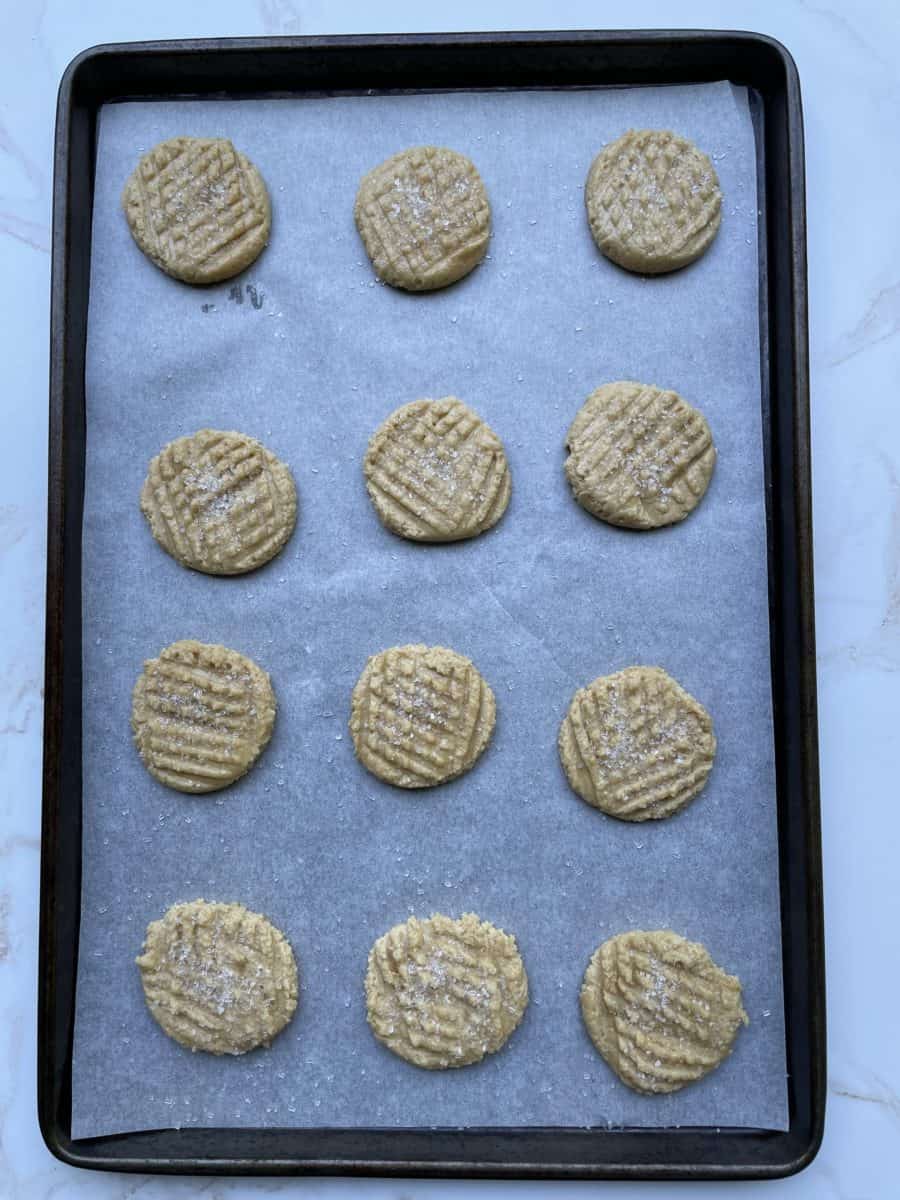 Formed Peanut Butter Cookie Dough on a baking sheet.