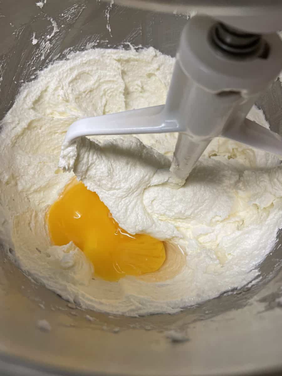 Once the butter mixture is creamed, add the egg yolks, one at a time to the mixing bowl.