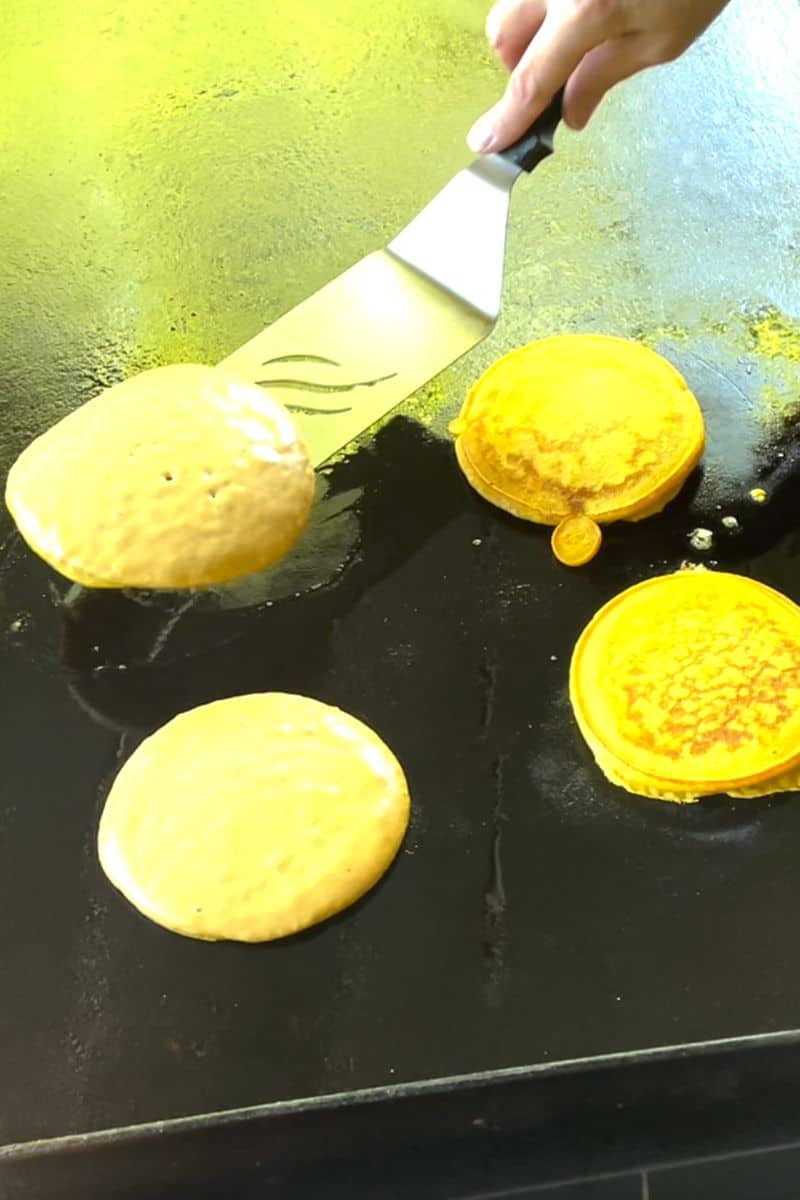 Use a griddle spatula to flip the pumpkin pancakes over.