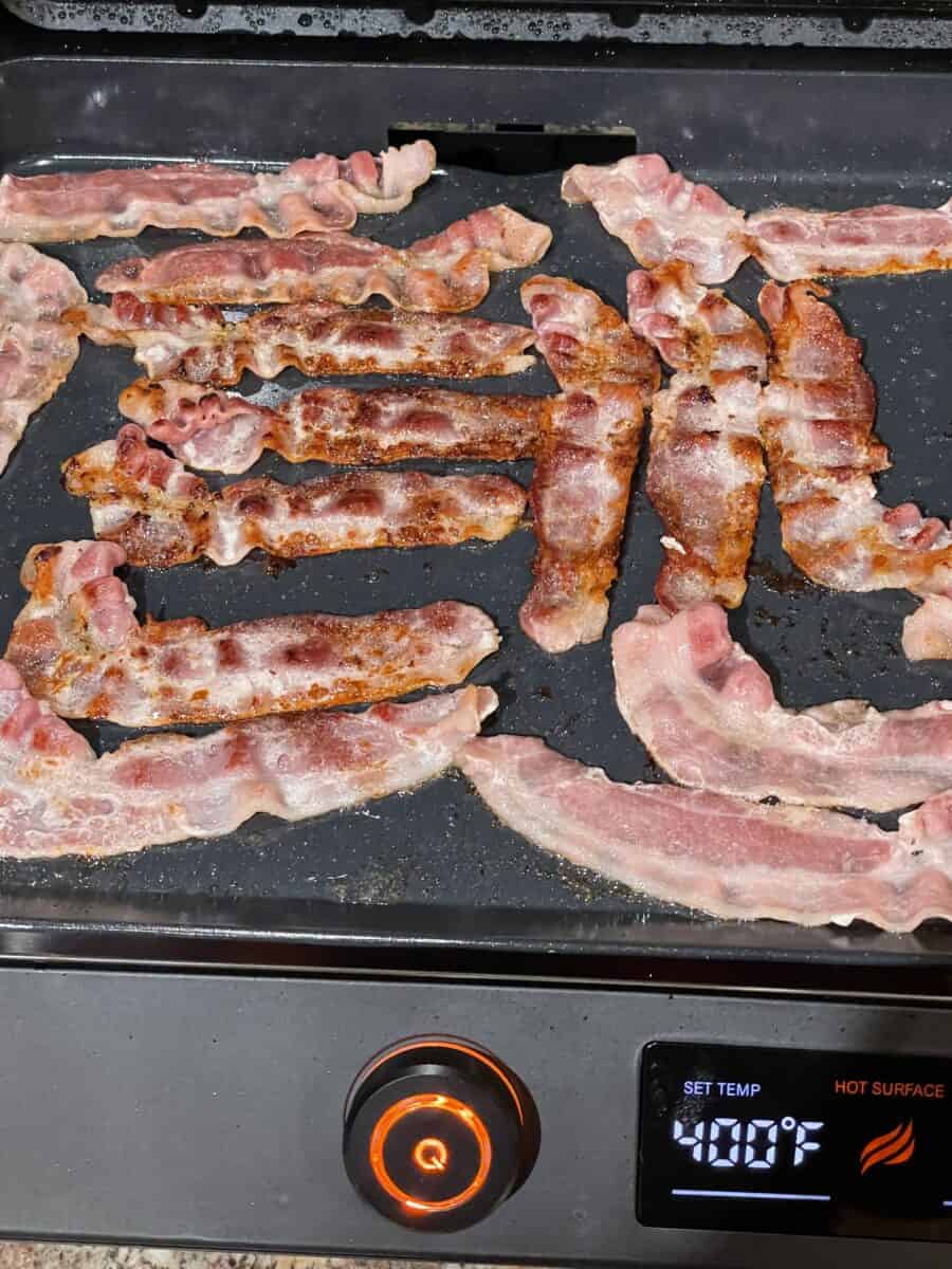 Bacon cooking on an Electric Blackstone Griddle.