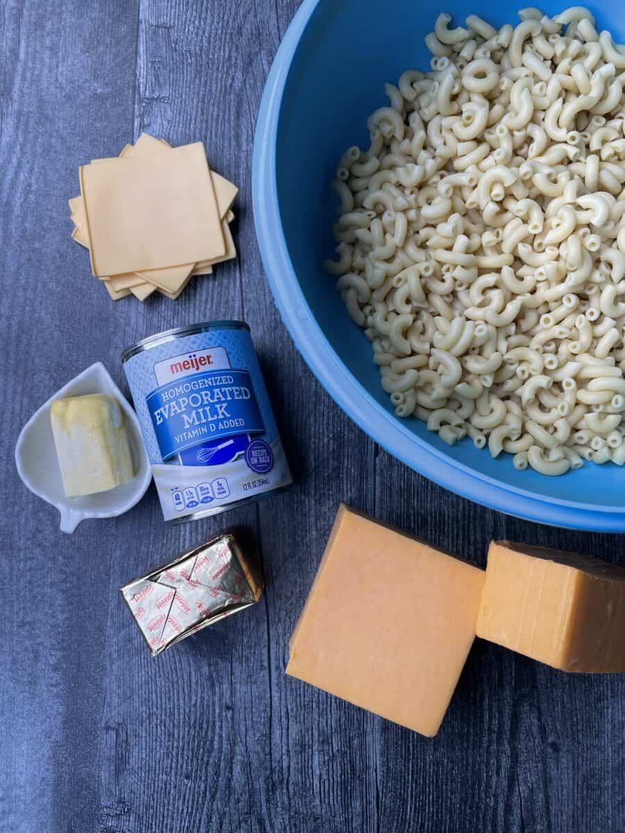 Smoked Mac n Cheese Ingredients - cooked macaroni noodles in a large bowl, Colby, Sharp Cheddar, and Velveeta Cheese, canned milk, butter/margarine, and American Cheese Slices.,