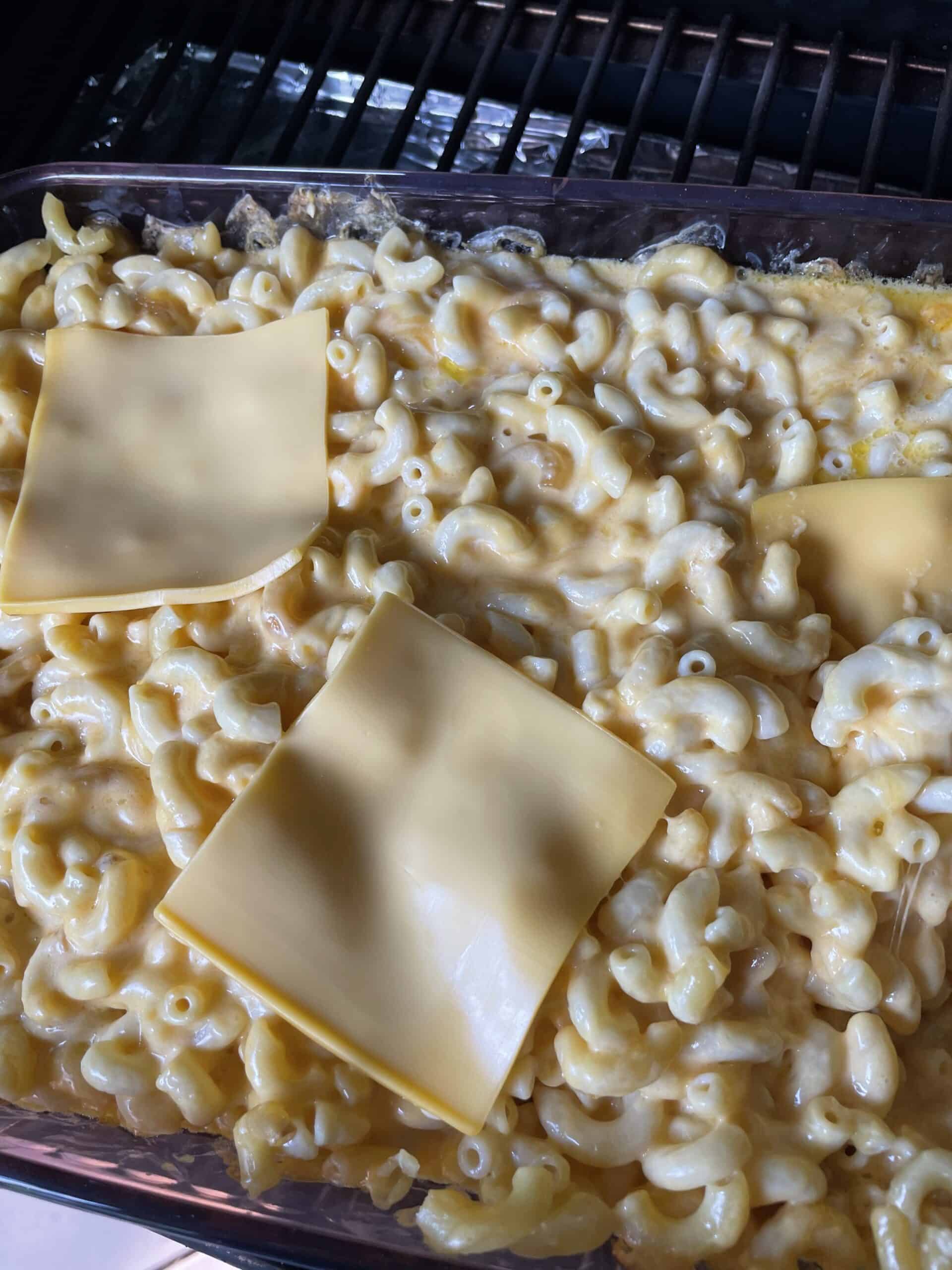 Adding the last of the American cheese slices to the smoked mac n cheese.