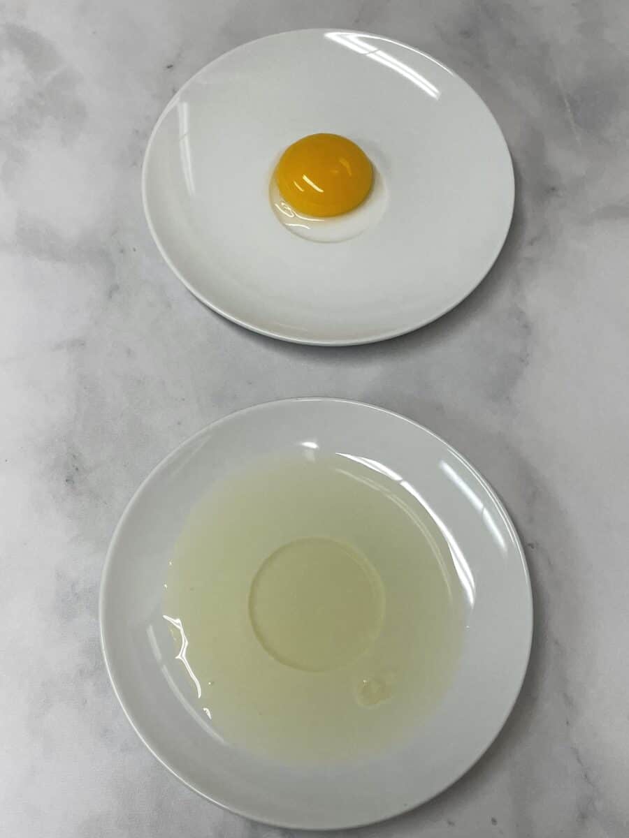 Egg Yolk on a plate and an egg white on a plate.