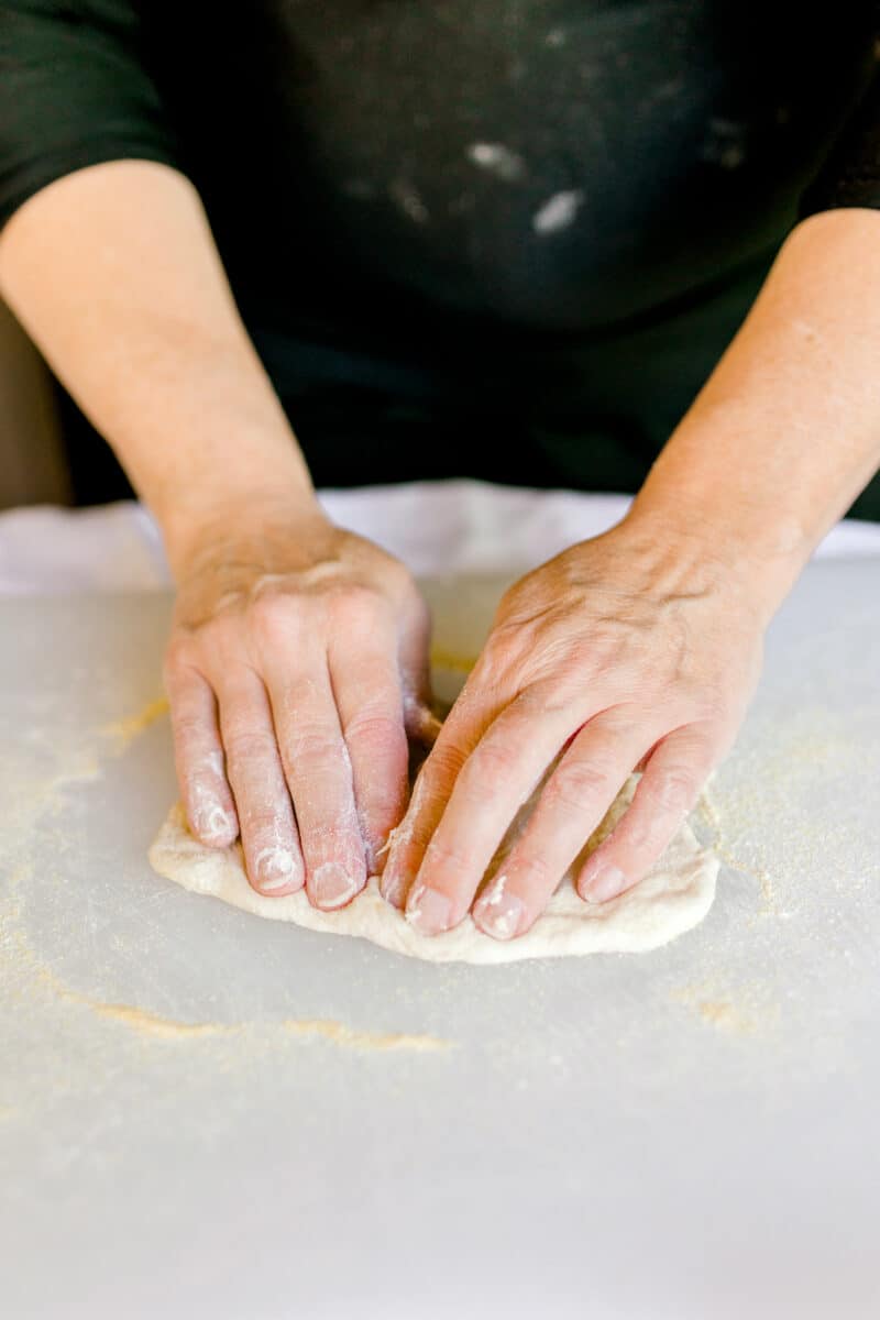 Pressing Out Homemade Pizza Dough with your Fingers.