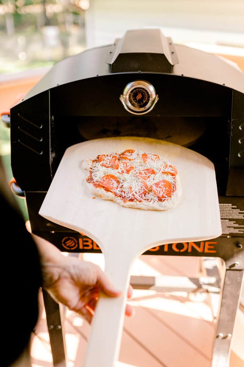 Using a Pizza Peel to put a Homemade pizza in the Blackstone Pizza Oven.