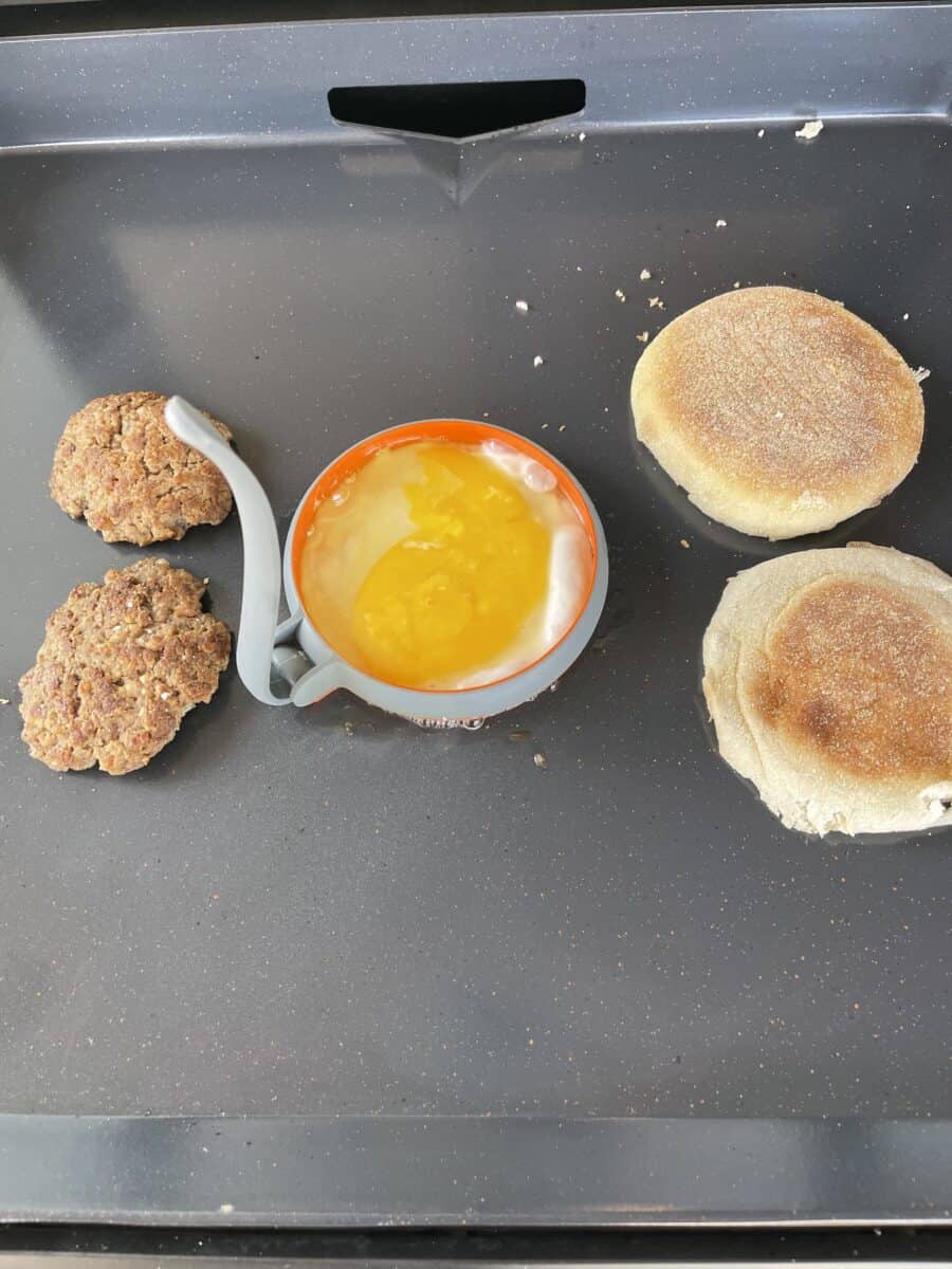 Cooking on a Blackstone Electric Griddle: English Muffin, An Egg Patty, and Sausage Patties.