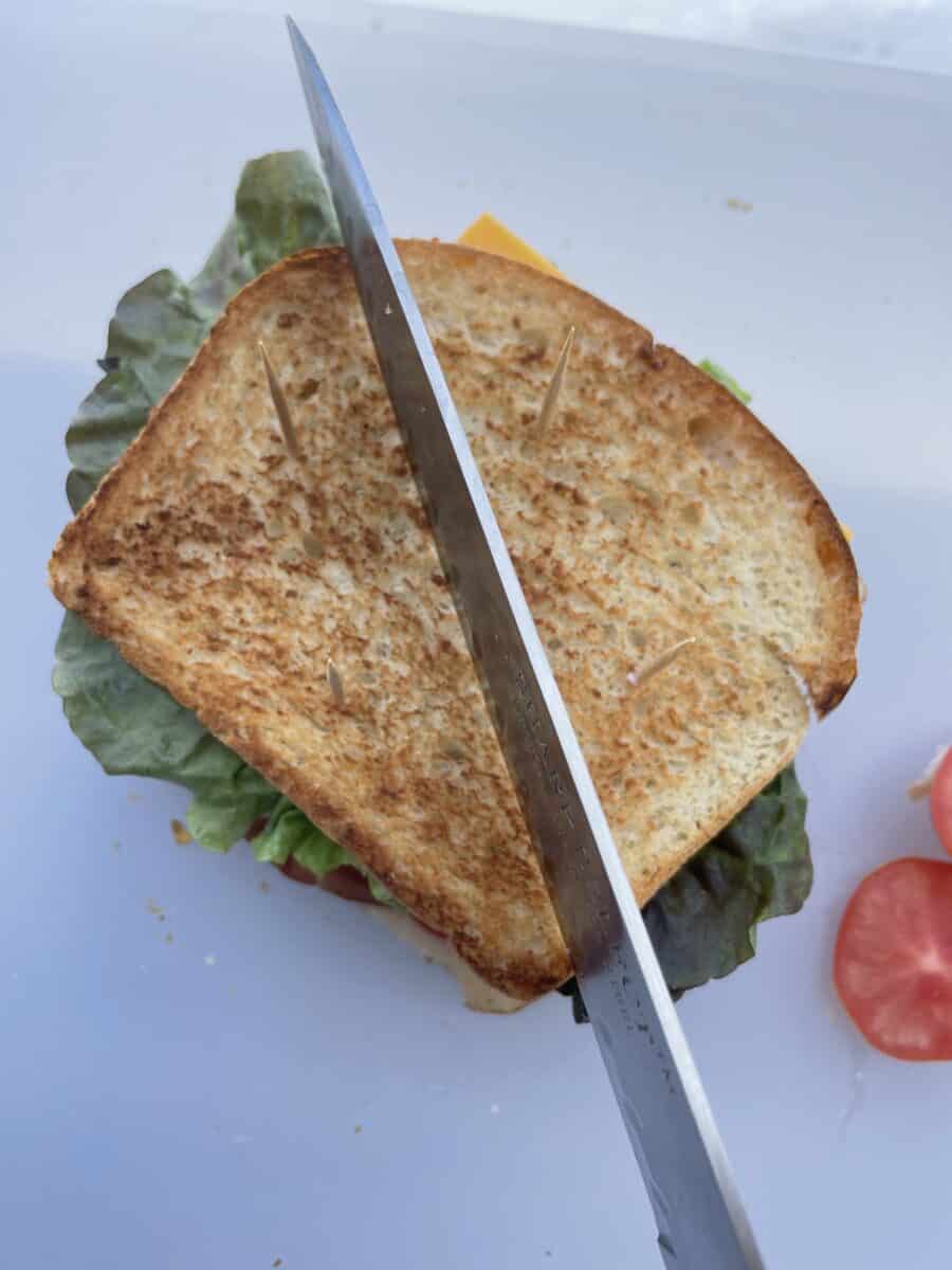 Cutting the sandwich from one corner to the opposite corner.