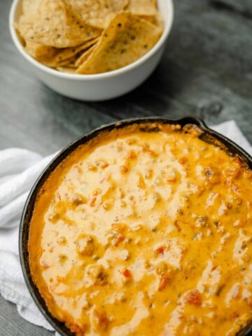 Smoked Queso Dip in a Cast Iron Pan with a side of Tortilla Chips.