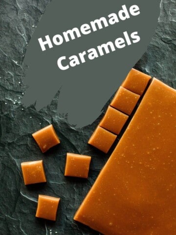 A slab of homemade caramel along with square pieces of caramel all on a board.
