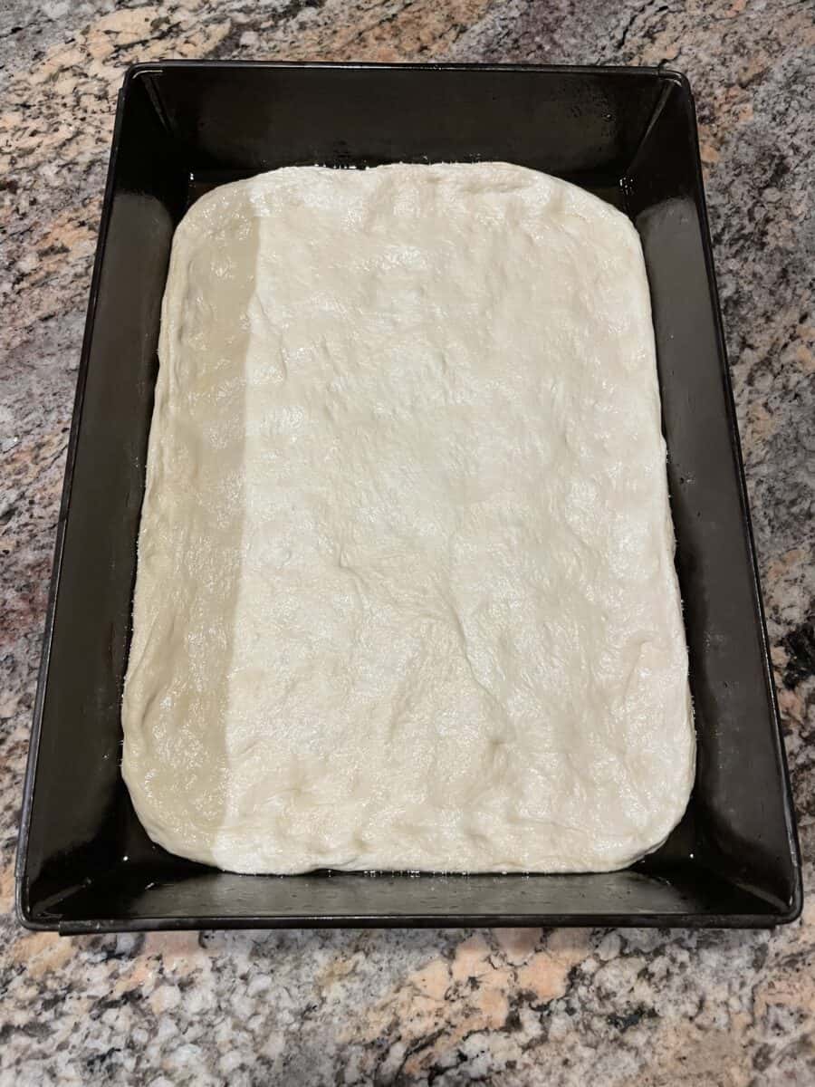 Pizza Dough Completely Pressed into to Bottom of a Detroit Pizza Pan.