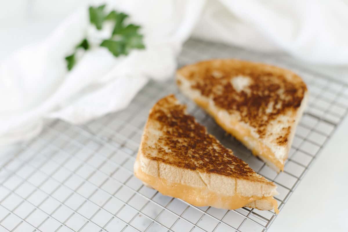 The Best Grilled Cheese on a wire rack with a cloth napkin on the side.