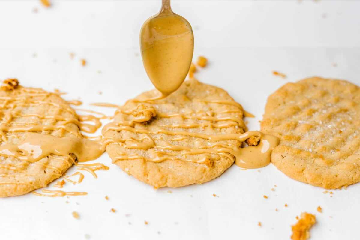 Dripping Melted Peanut Butter on top of Peanut Butter Cookies with a Spoon.