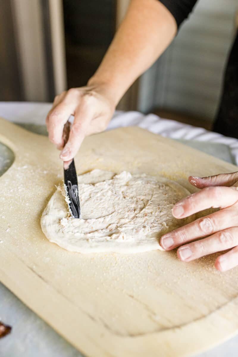 Spread a Layer of Smoked Fish Dip onto Pizza Dough on a Pizza Peel.