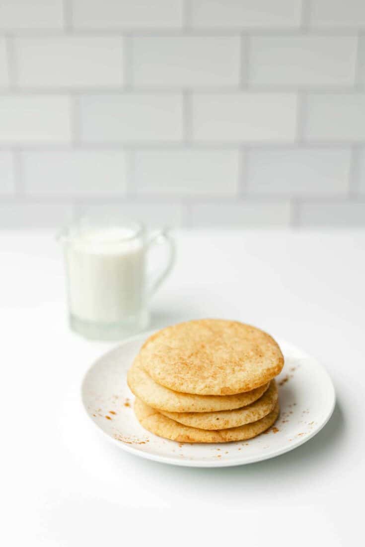 Snickerdoodles Cookie Recipe stacked on a plate with a side of milk.