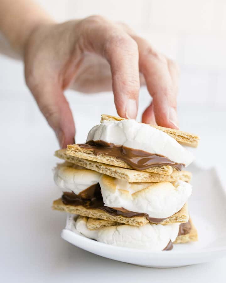 A Hand Holding a Stack of Smores made in the Blackstone Pizza Oven.