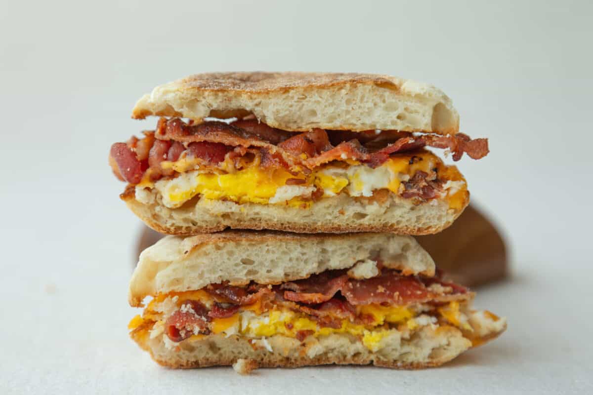 Bacon Cheese and Egg Sandwich Cut in Half and Stacked on Top of Each Other. 