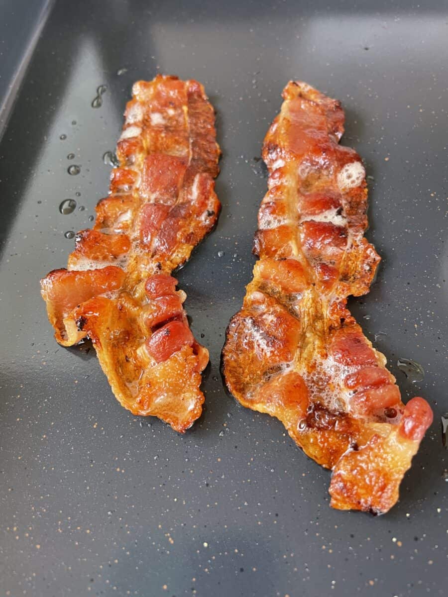 Bacon Strips Cooking on a Blackstone Electric Griddle.