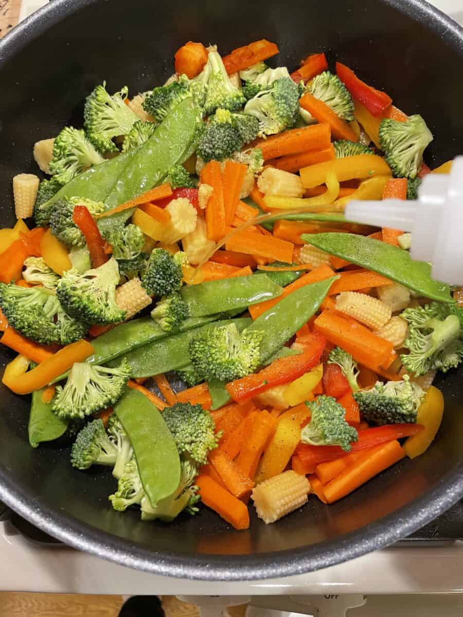 Adding Water to Steam Stir Fry Vegetables in a Pan.