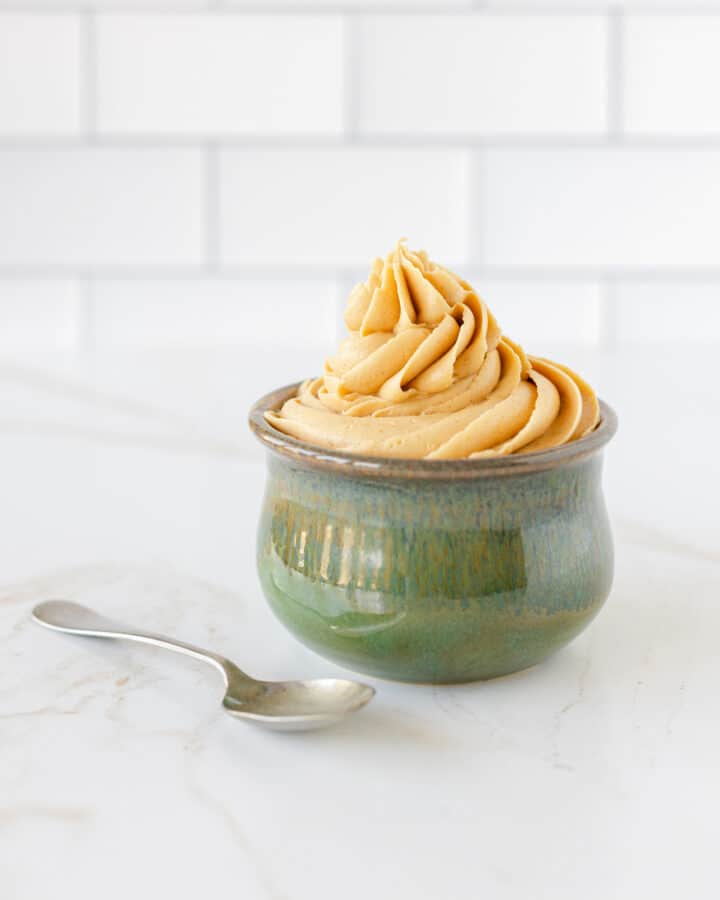 Peanut Butter Frosting in a small bowl along with a spoon.