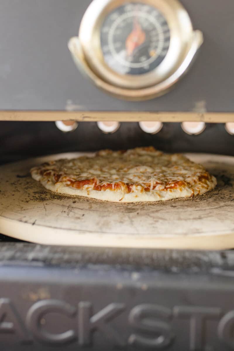 A Cheese Pizza Cooking in a Blackstone Pizza Oven.