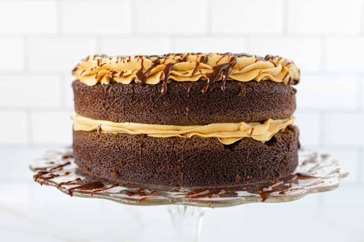 Crazy Cake Recipe Topped with Peanut Butter Frosting and a Drizzle of Chocolate Ganache.
