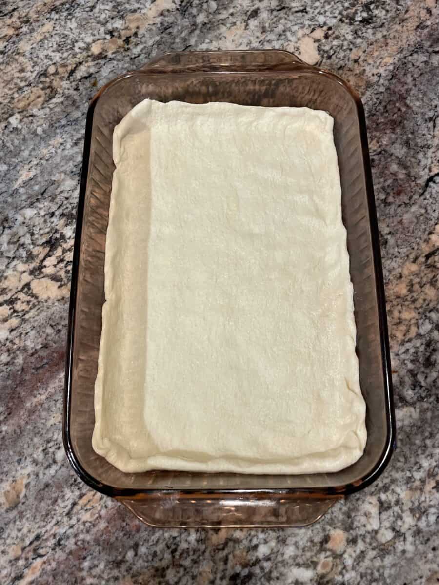 Crescent Roll Dough Sheet Pressed in the Bottom of a Pyrex Baking Pan.