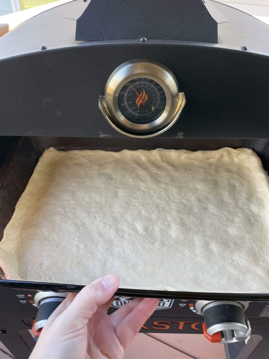 Placing the Prepared Crescent Dough Baking Pan into the Blackstone Pizza Oven.  