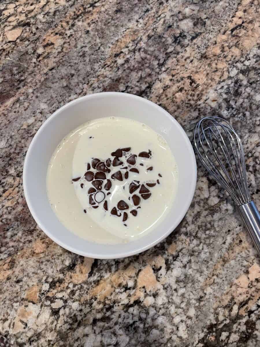 Warm Heavy Whipping Cream Poured in a Bowl of Semi-Sweet Chocolate Chips.