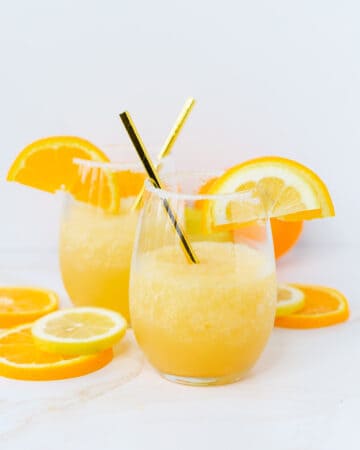 Whiskey Slush in a glass garnished with orange and lemon slices.