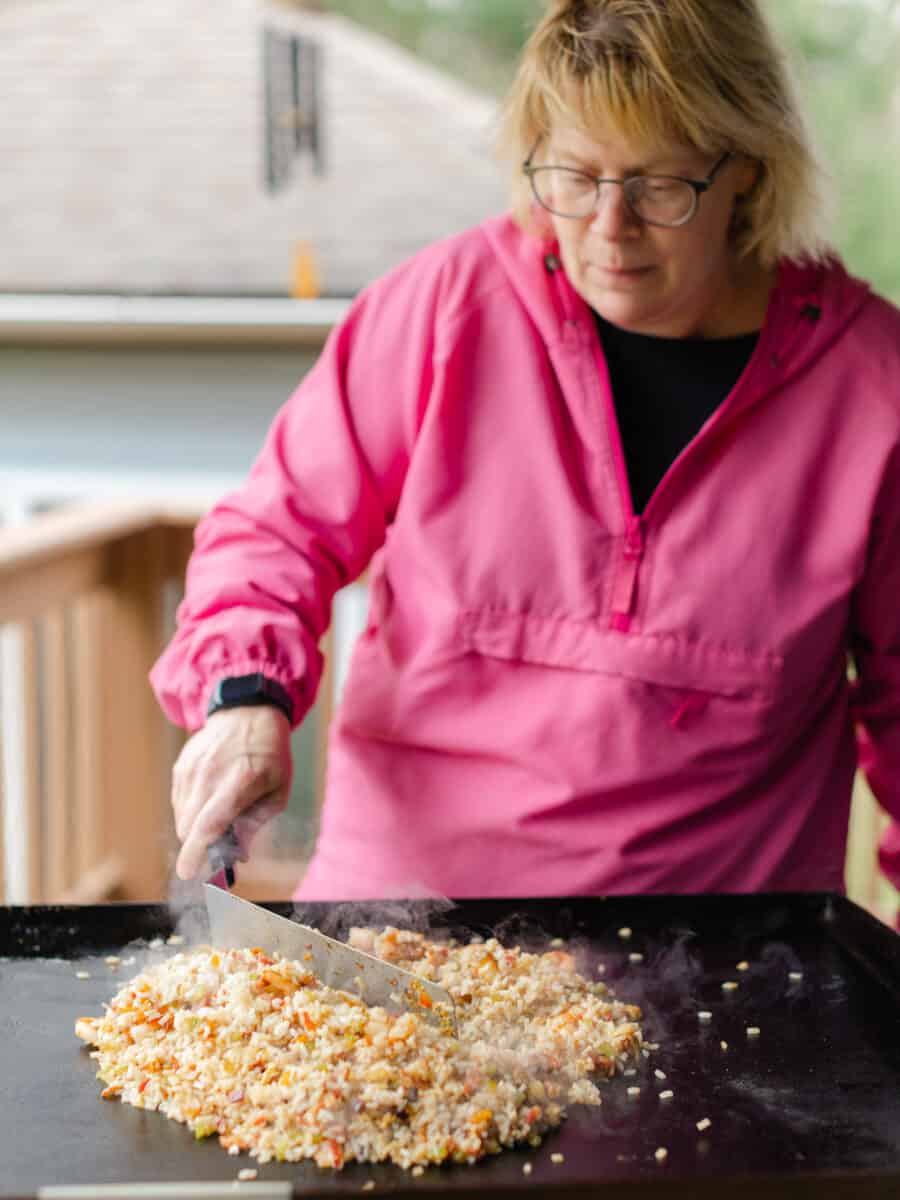 Using a Griddle Spatula to Stir Shrimp Fried Rice Recipe on a flat top griddle.