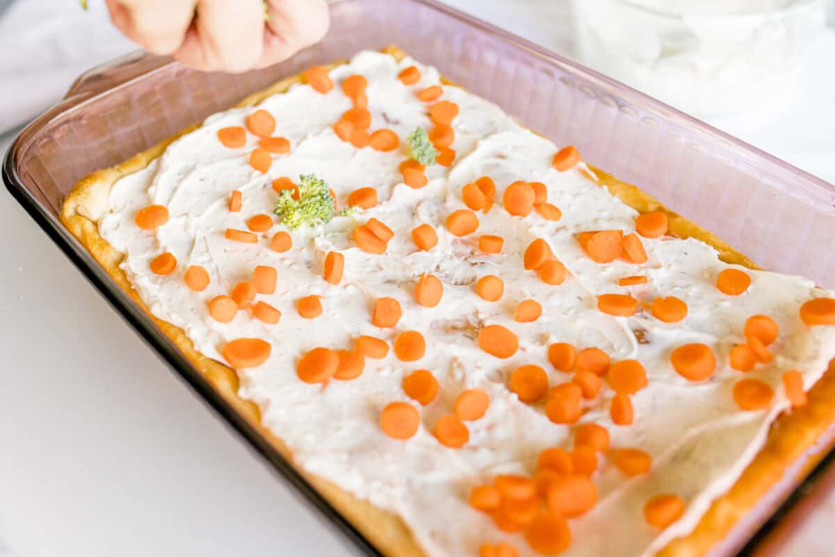 A Sprinkled Layer of Diced Carrots on top of a Cream Cheese - Crescent Roll Crust.