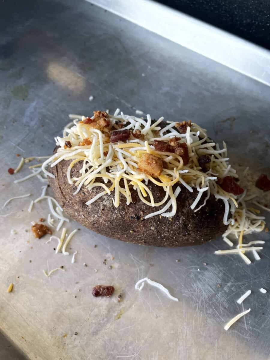 Smoked Baked Potato Topped with Shredded Cheese and Crumbled Bacon.