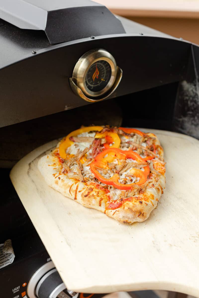 Removing the Fully Cooked Pulled Pork Pizza from the Blackstone Pizza Oven.