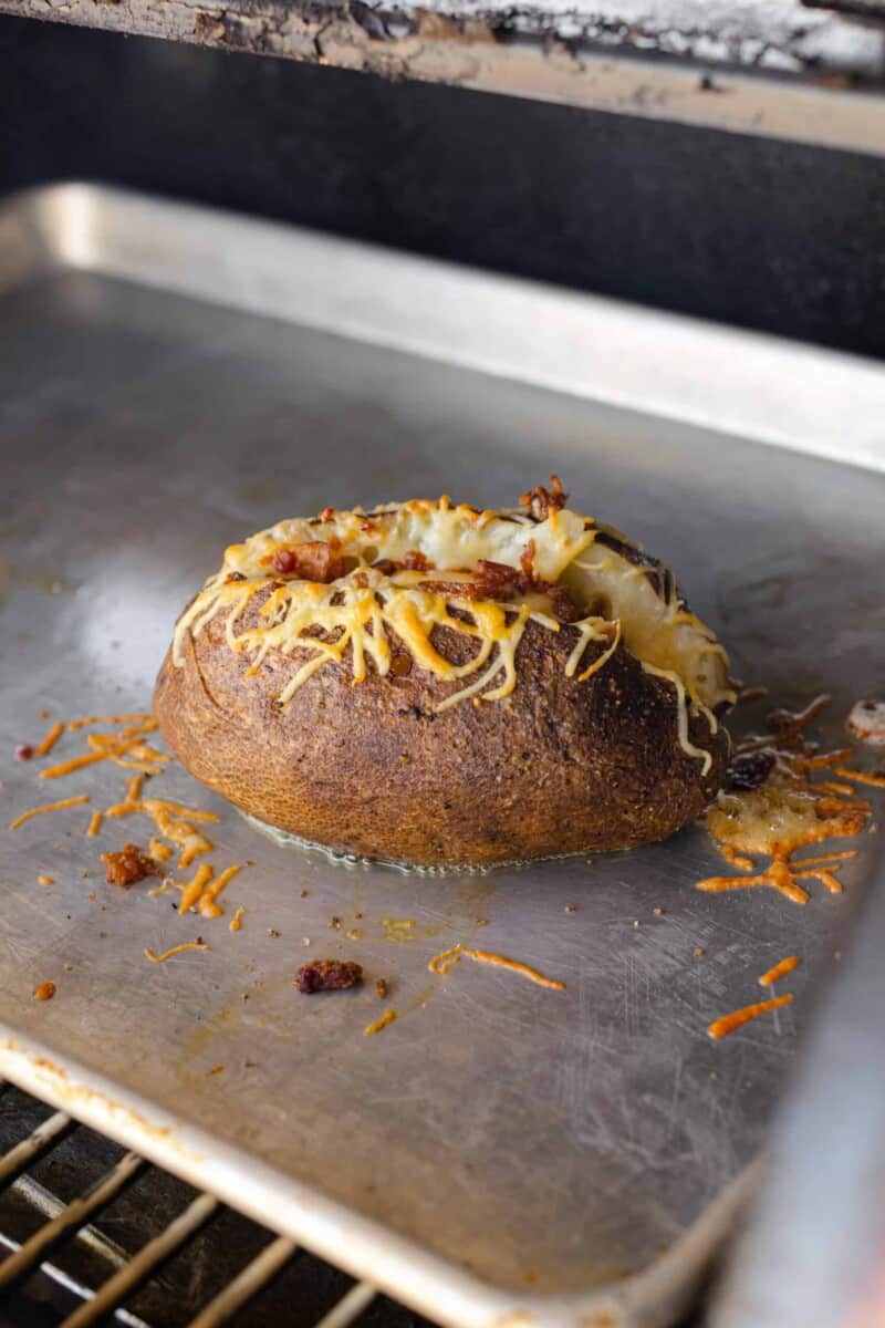 A Smoker Loaded Baked Potato on a Sheet Pan.