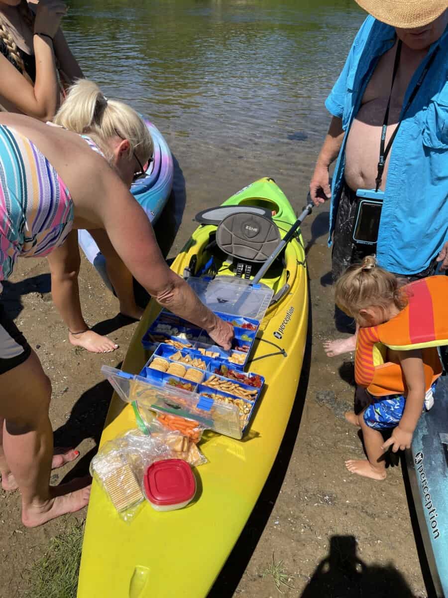 Kayakers Enjoying Snacks from a tackle box charcuterie.