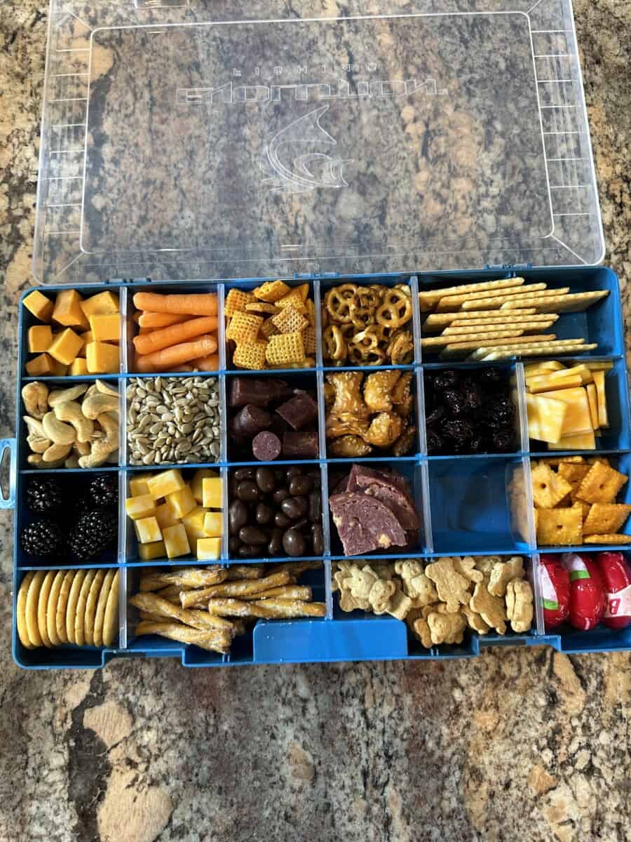 A Tackle Box Charcuterie filled with an Assortment of Different Snacks.