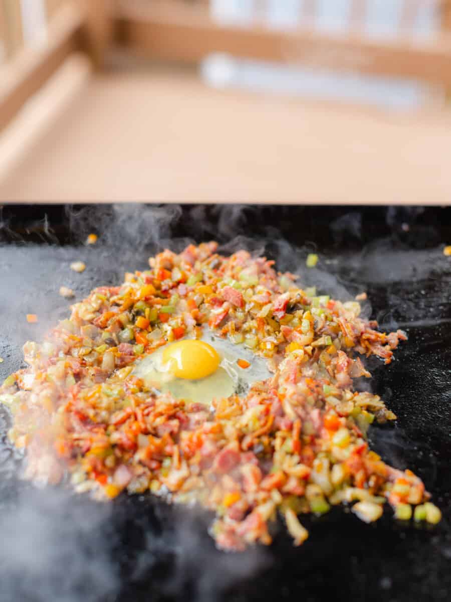 Cooking an Egg in the Middle of Diced Bacon and Vegetable Pieces