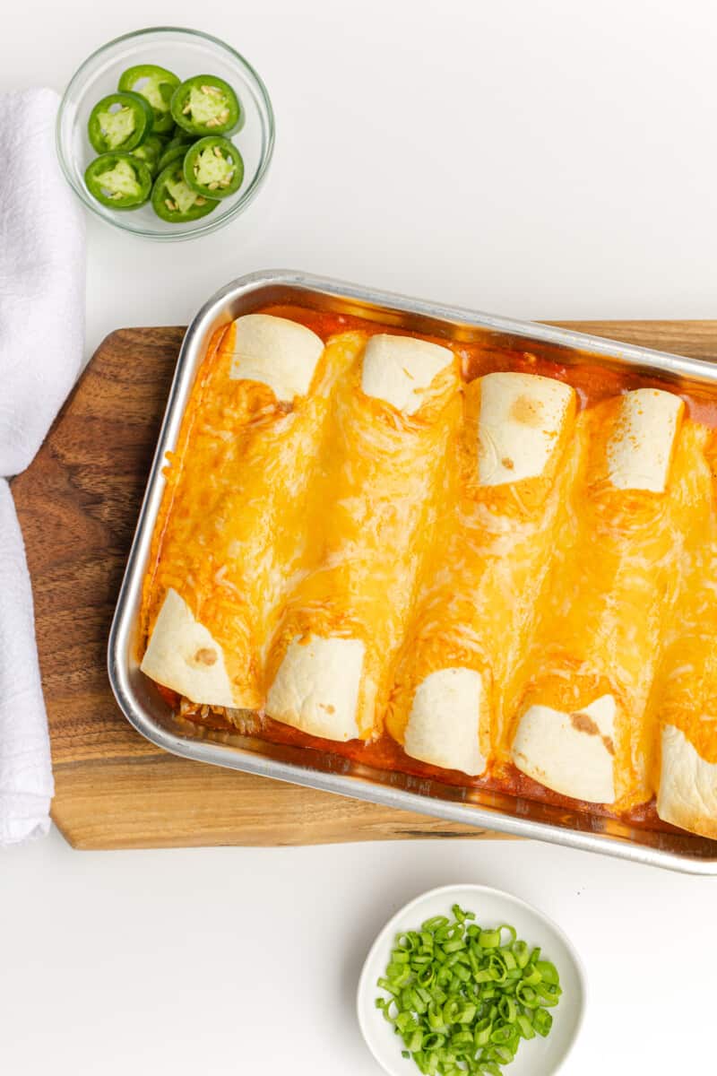 Fully Cooked Pork Enchilada Recipe with a Side of Sliced Jalapeños and Chopped Green Onions.