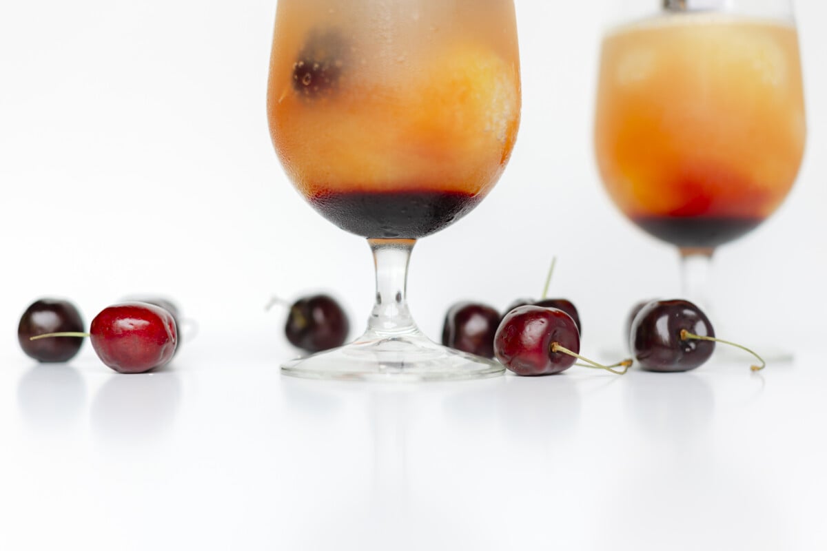 Whiskey Cherry Slush in a stem glass with fresh cherries