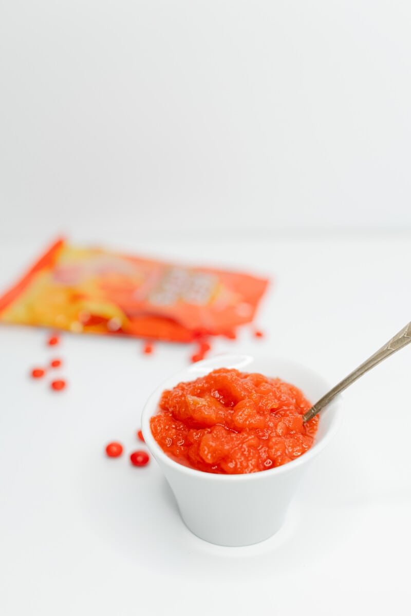 Red Hots Instant Pot Applesauce in a small bowl with Red Hots on the side.