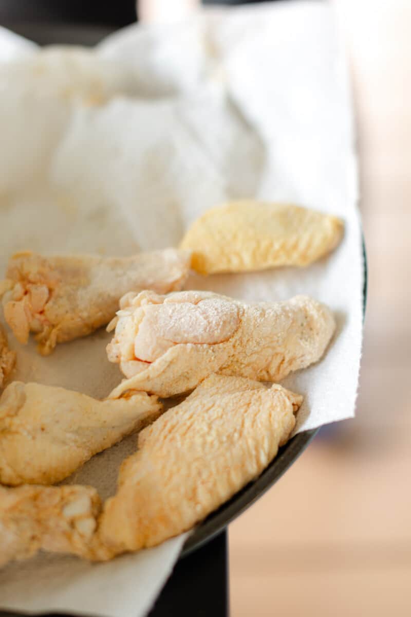 Uncooked Breaded Chicken Wing Pieces on a Plate.