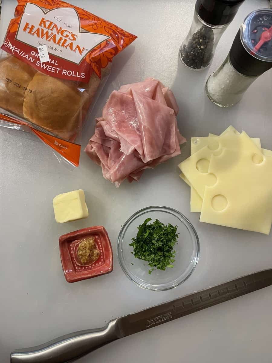 Ham Sliders Ingredients: Hawaiian Rolls, Sliced Ham, Swiss Cheese Slices, Butter, Minced Garlic, Chopped Parsley, Salt and Pepper