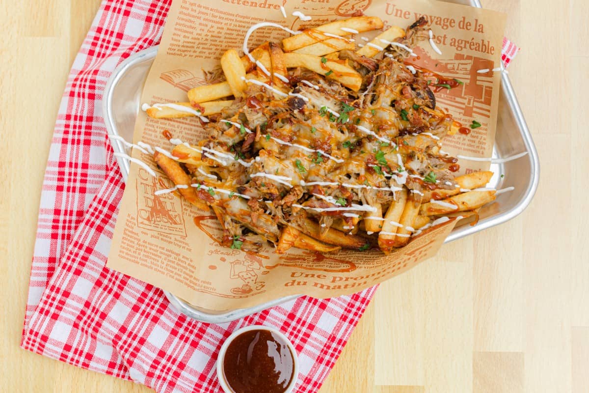Pulled Pork French Fries on a tray with a side of BBQ sauce