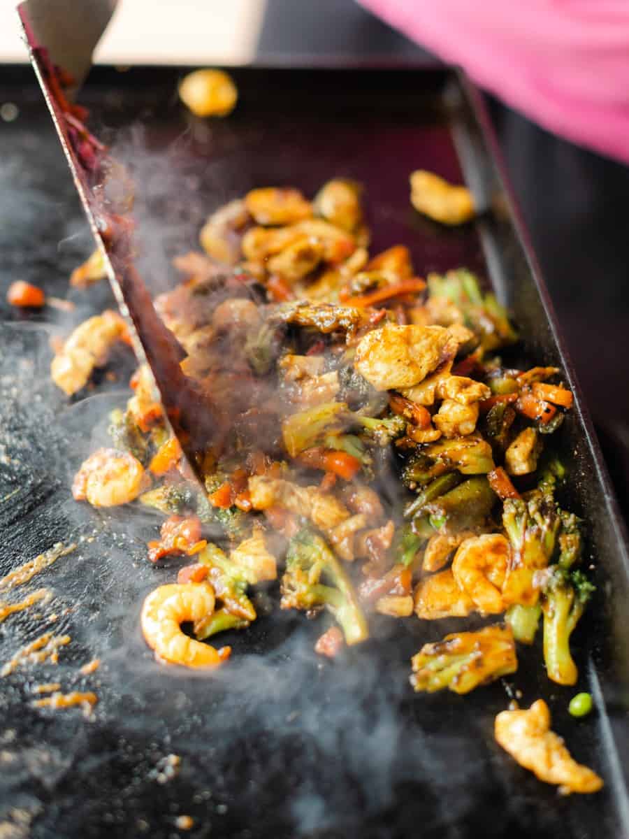 Using a Griddle Spatula to Combine the Stir Fry Recipe