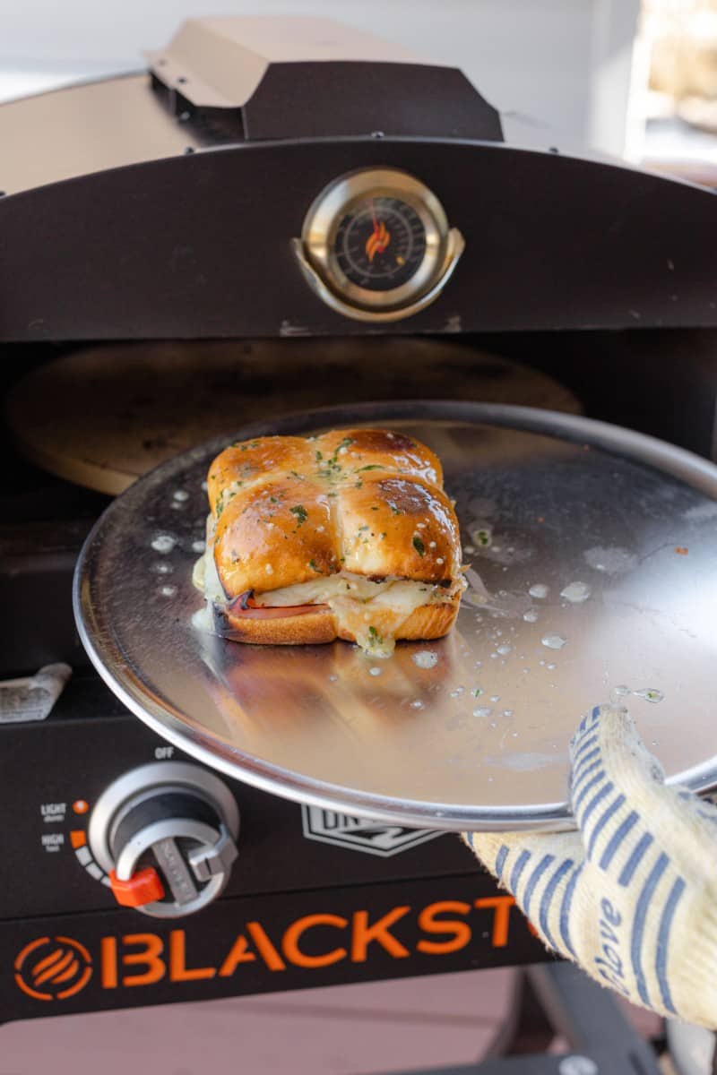 Placing the Ham Cheese Sliders into the Pizza Oven to Toast the Top
