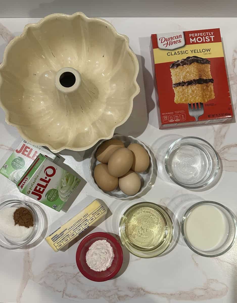 Ingredients for Bundt Cake Recipe - cake mix, pudding mix, eggs, water, oil, flour, sugar, cinnamon, milk, and butter.
