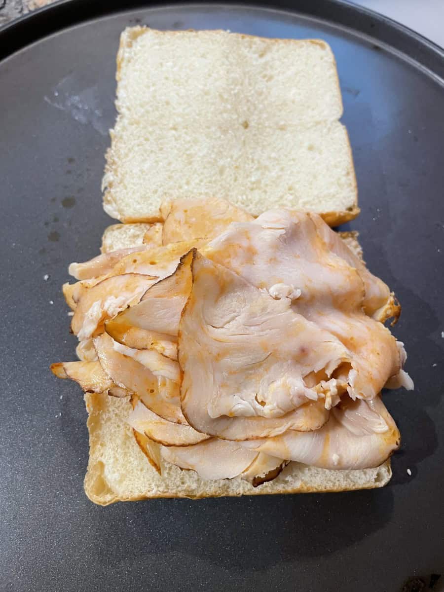 Cut the Rolls in Half and Layer the Sliced Deli Buffalo Chicken onto the bottom half of the rolls