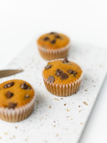 3 Pumpkin Chocolate Chip Muffins on a board